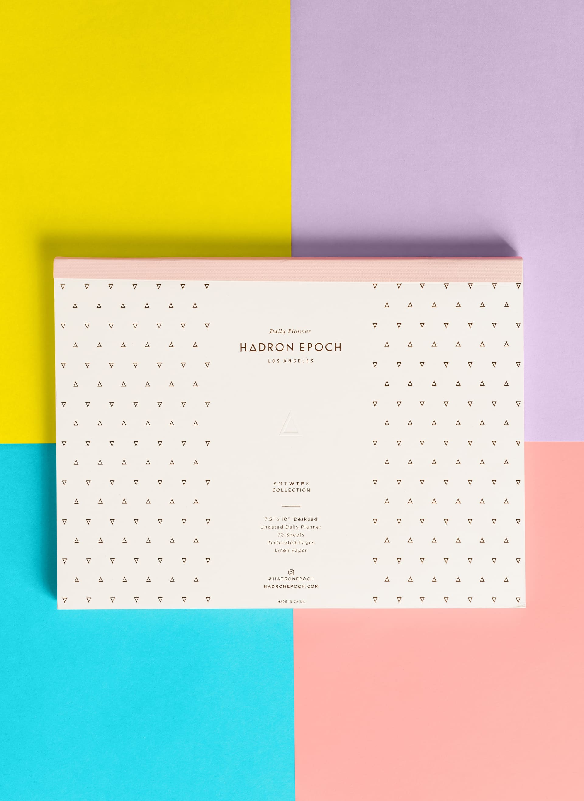 Hadron Epoch daily planner deskpad shot flat on a four-color paper background