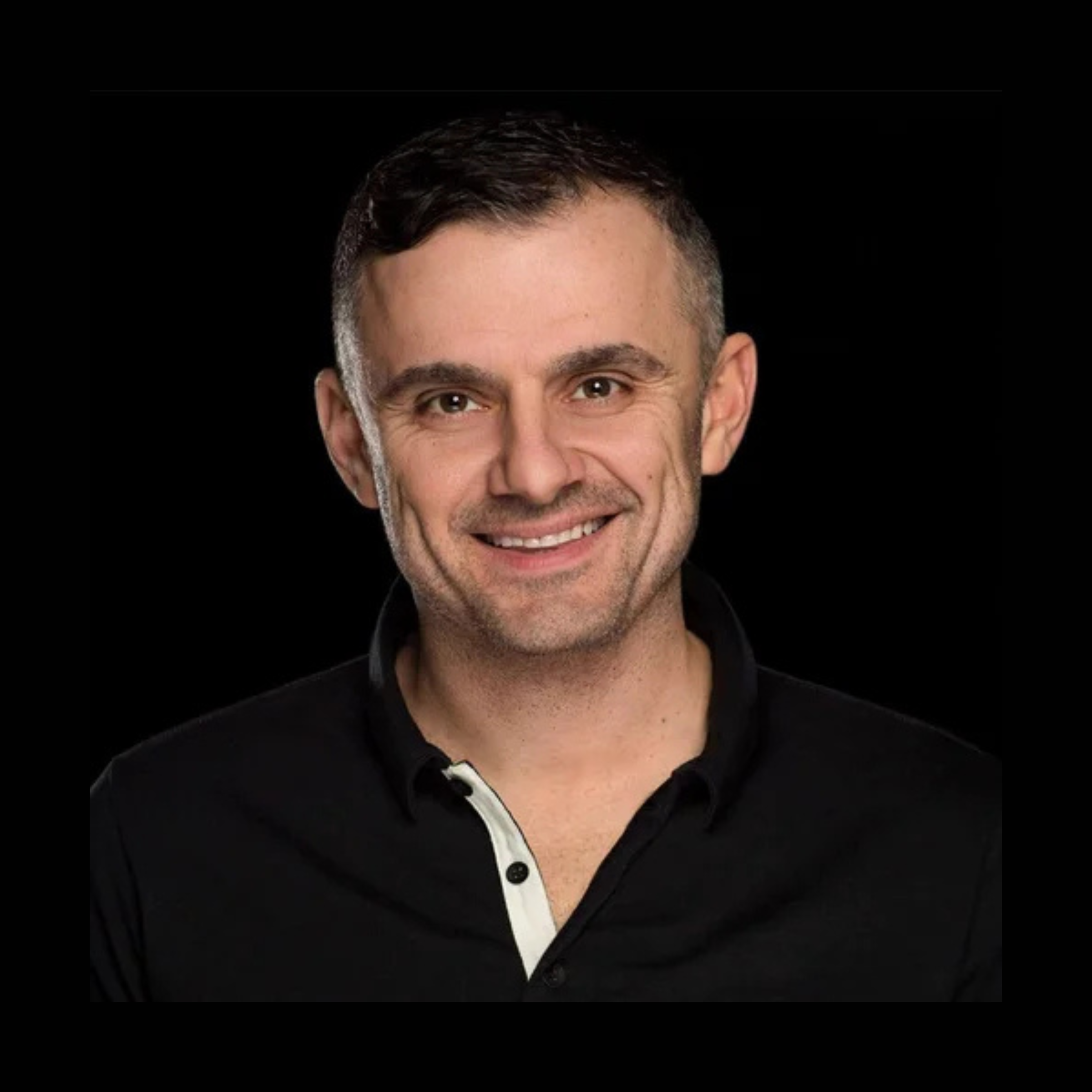 Headshot of a smiling person with short dark hair in a black collared shirt, lit against a black background